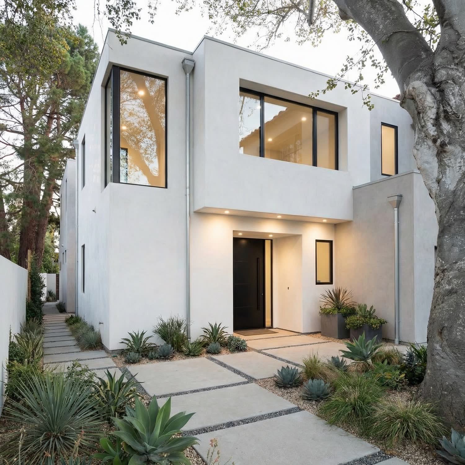 A modern two-story custom home with a landscaped, drought-tolerant front yard.