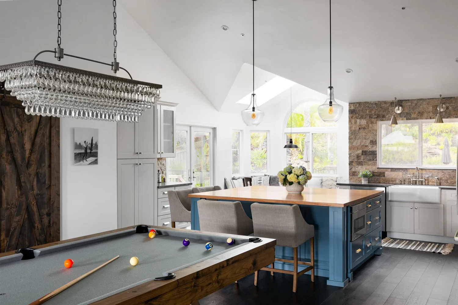 A bright remodeled kitchen with a large island, custom cabinetry, and natural light.